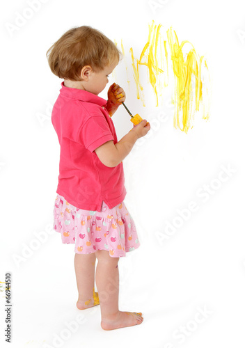 malująca dziwczynka żółtą farbą po ścianie