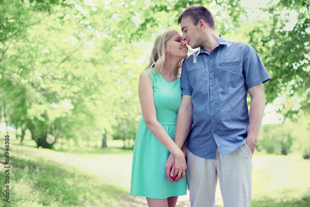 Fototapeta premium Lovely tender young couple in love walking in sunny spring park,