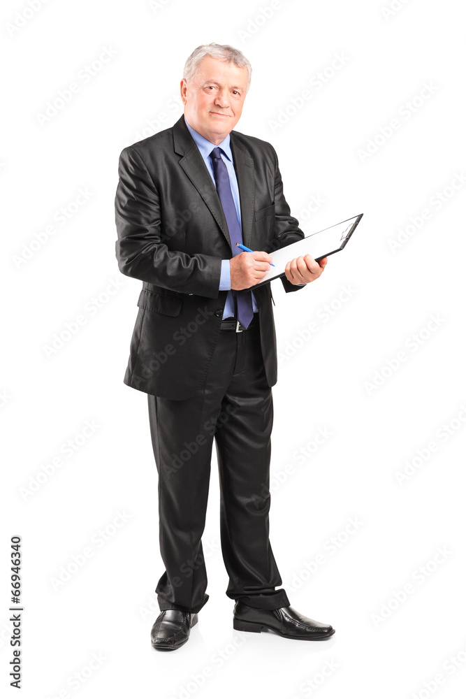 Mature businessman taking notes on piece of paper Mature businessman taking notes on piece of paper