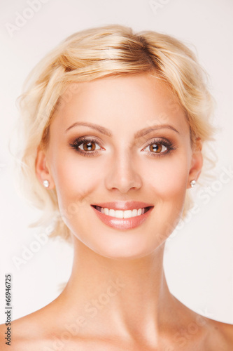 Portrait of beautiful smiling woman with healthy teeth on white
