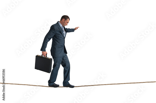 isolated businessman balancing tightrope