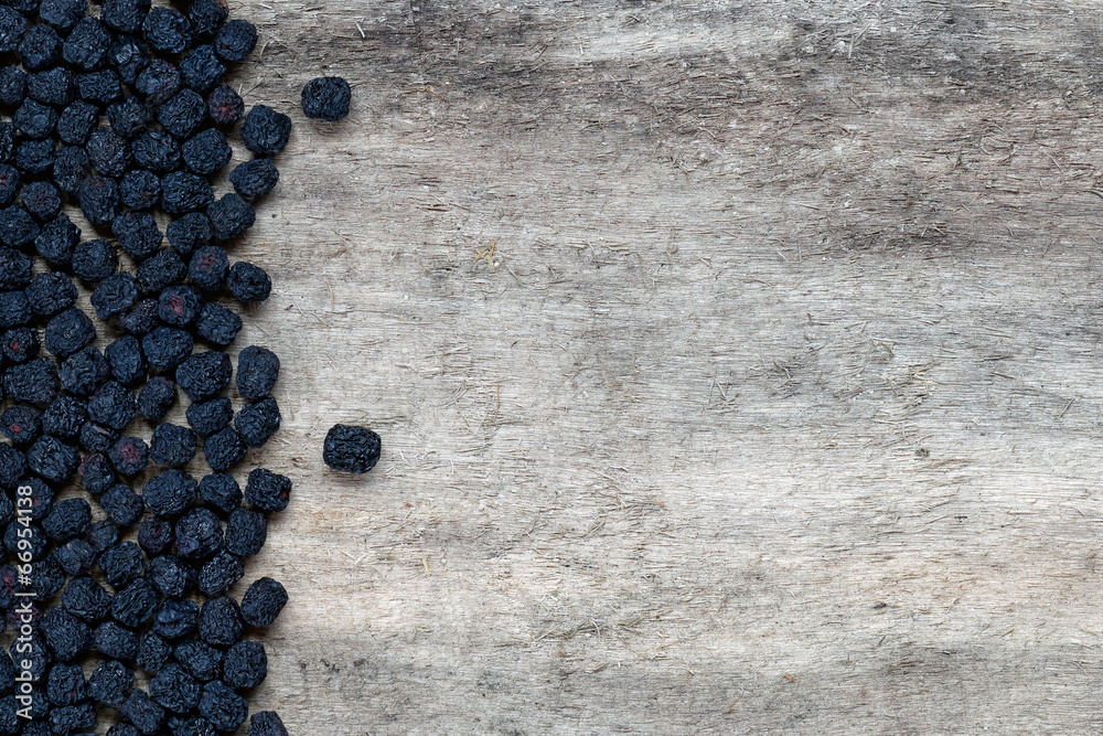 Dried aronia berries on wooden background Dried aronia berries on wooden background