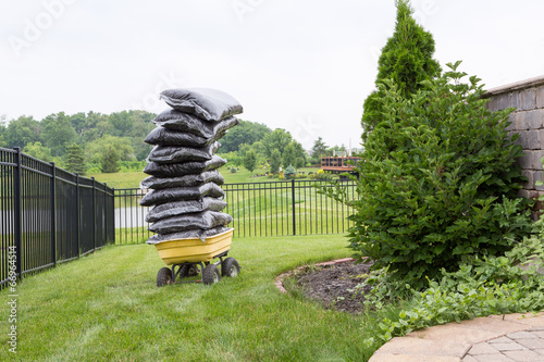 Fotografie Mulch in bags piled high on a cart in the garden