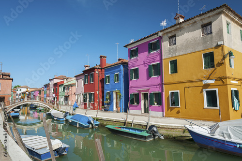 Burano island canal, colorful houses and boats, Italy. © leeyiutung