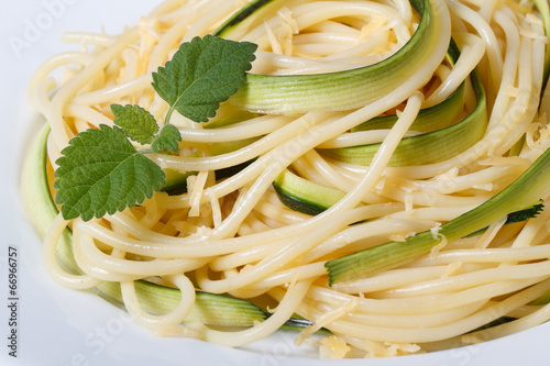 spaghetti with zucchini and mint on a plate macro horizontal