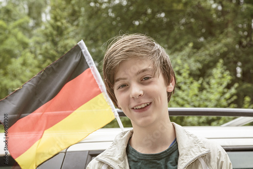 smiling male teenager in front of a german flag