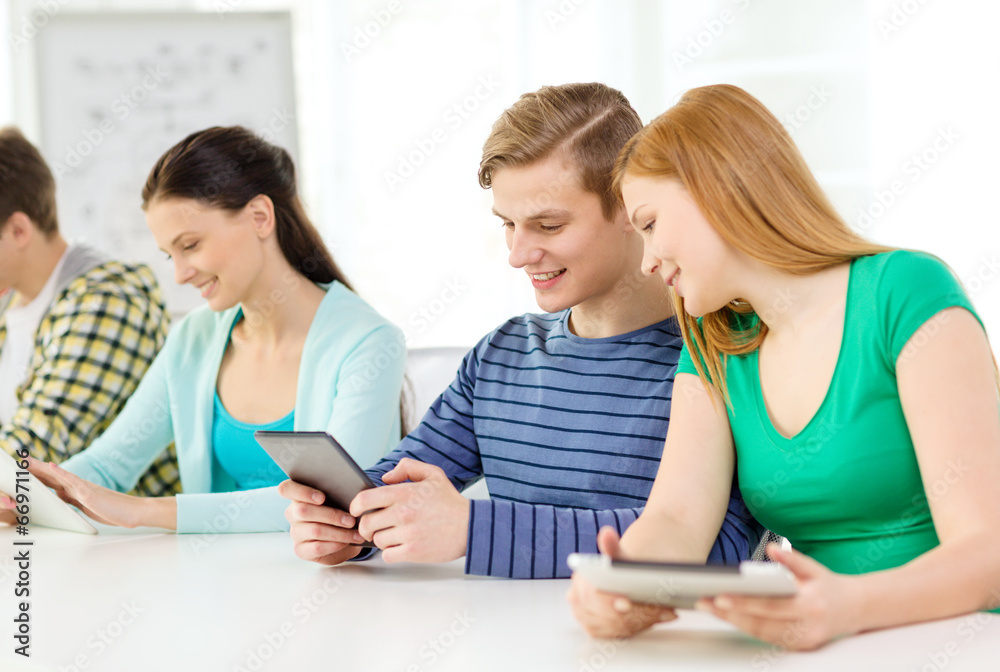 smiling students with tablet pc at school