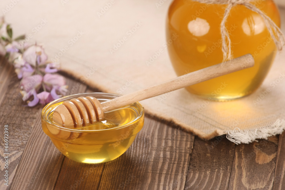 honey in a glass bowl on a wooden boards background honey in a glass bowl on a wooden boards background