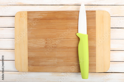 Kitchen knife and cutting board on wooden table