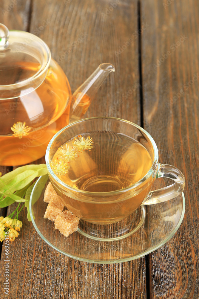 Tasty herbal tea with linden flowers on wooden table Tasty herbal tea with linden flowers on wooden table