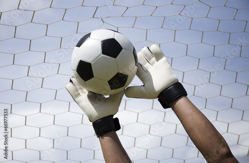 Foto goalkeeper's hands reaching foot ball