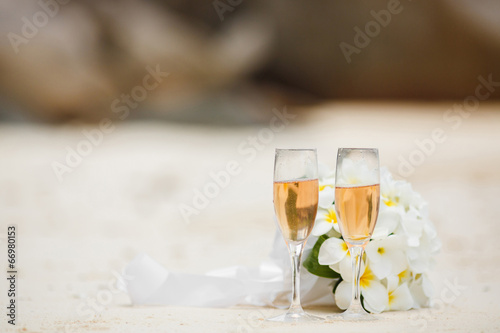 wedding bouquet of frangipani and champagne glasses