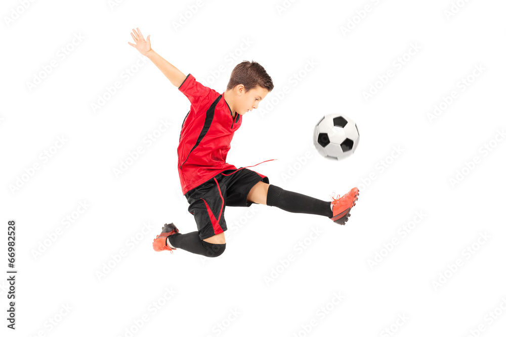 Junior football player kicking a ball