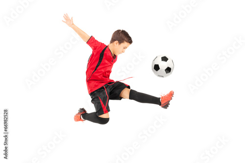 Junior football player kicking a ball