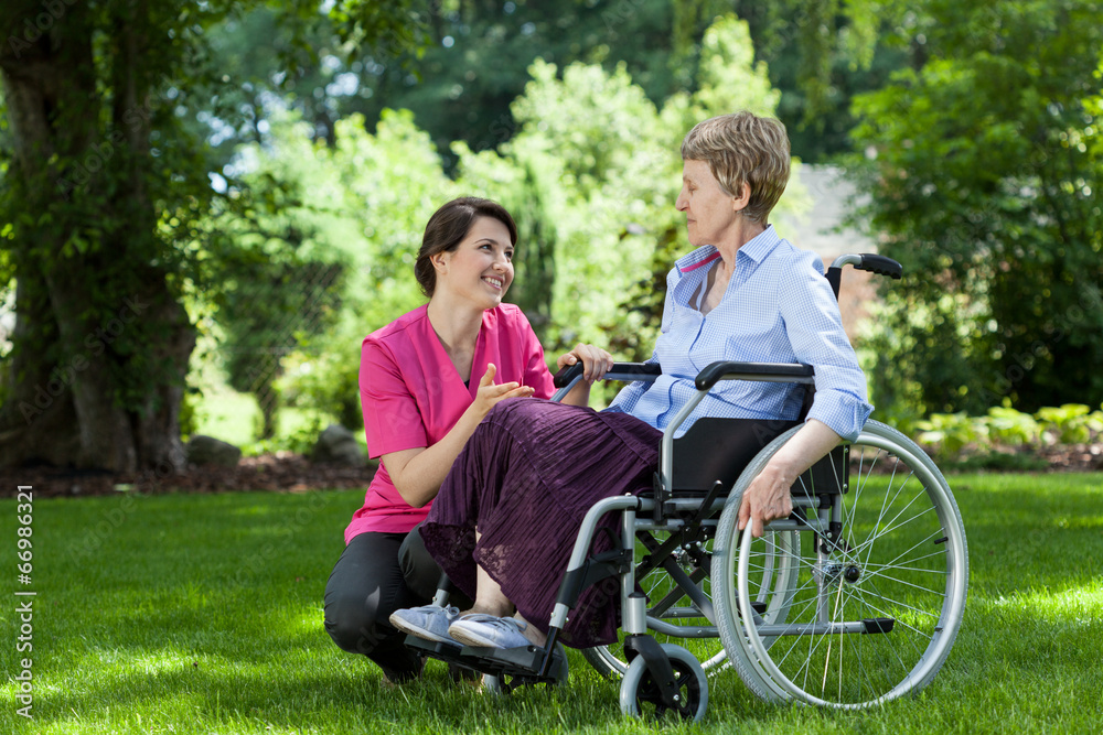 Woman on wheelchair relaxing in garden Woman on wheelchair relaxing in garden