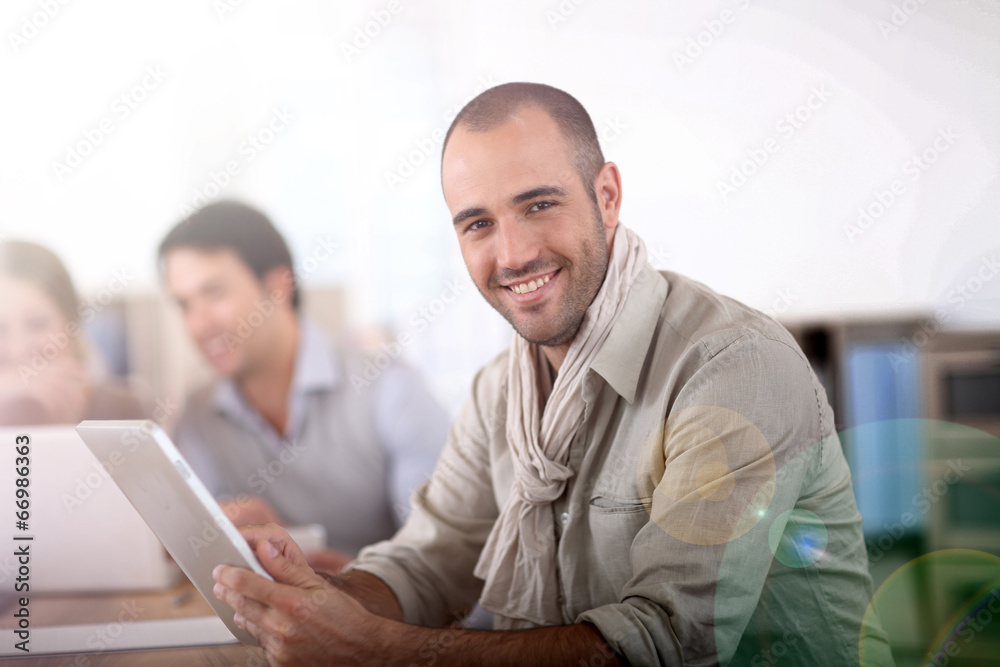 Smiling man in office using digital tablet Smiling man in office using digital tablet