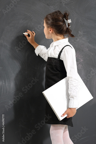 schoolgirl writes on the blackboard
