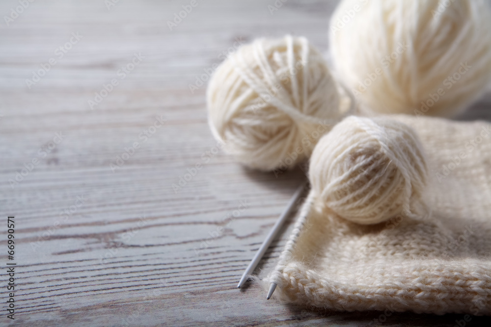 Ball of yarn and knitting on a wooden table