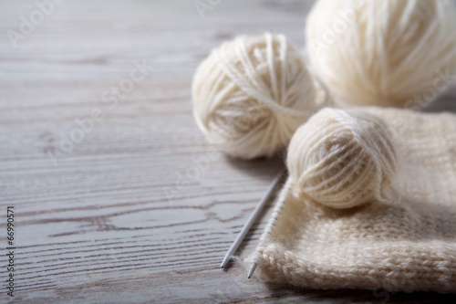 Ball of yarn and knitting on a wooden table