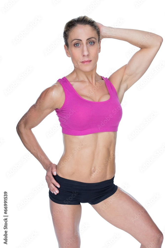 Female bodybuilder posing in pink sports bra Female bodybuilder posing in pink sports bra