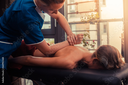 Massage therapist treating a client photo