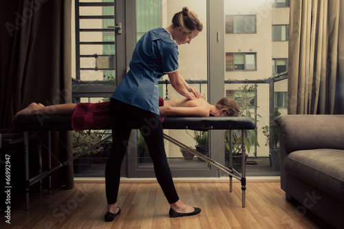 Massage therapist treating patient at home photo