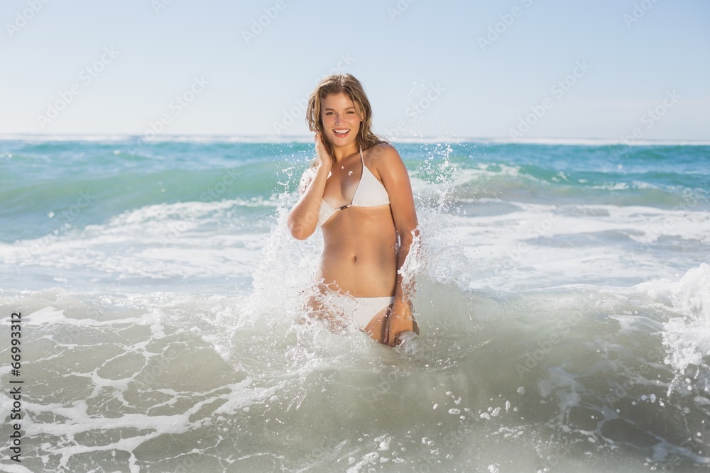 Beautiful smiling woman in white bikini standing in the sea Beautiful smiling woman in white bikini standing in the sea