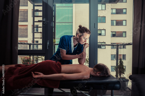 Massage therapist treating patient at home photo