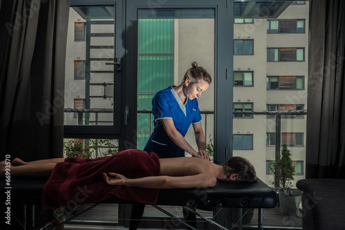 Massage therapist treating patient at home photo