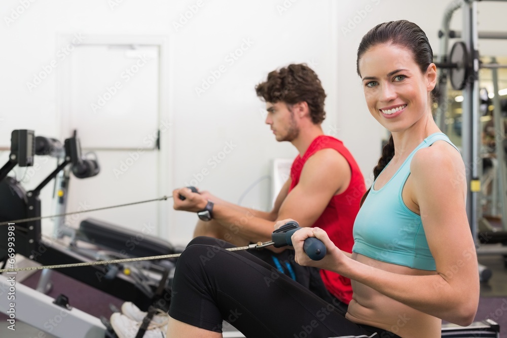 Smiling brunette working out on the rowing machine