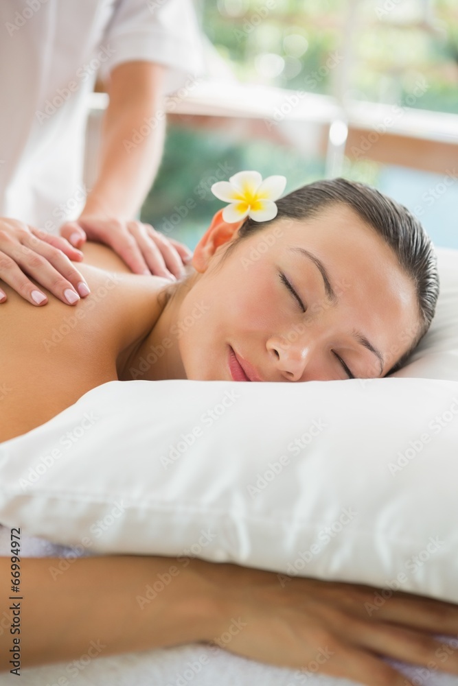 Smiling brunette getting a shoulder massage Smiling brunette getting a shoulder massage