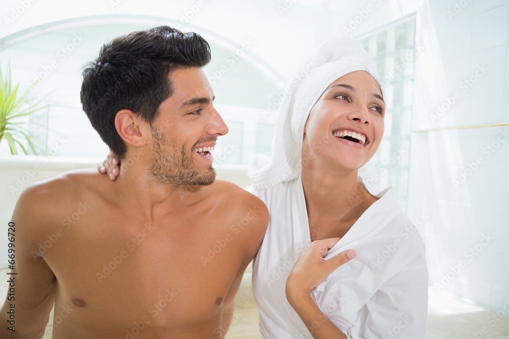 Fototapeta premium Attractive couple laughing in towels