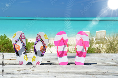 Two pairs of flip-flops against Atlantic. Exuma, Bahamas