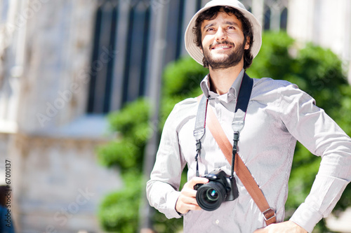 Smiling turist holding his camera photo