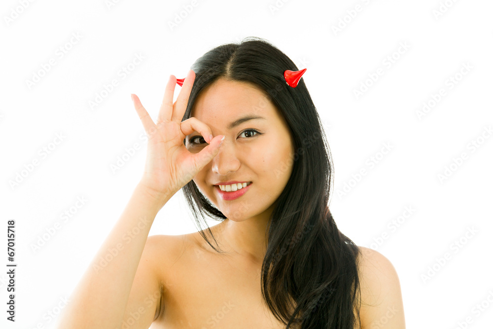 Devil side of a young naked Asian woman showing OK sign and Stock Photo