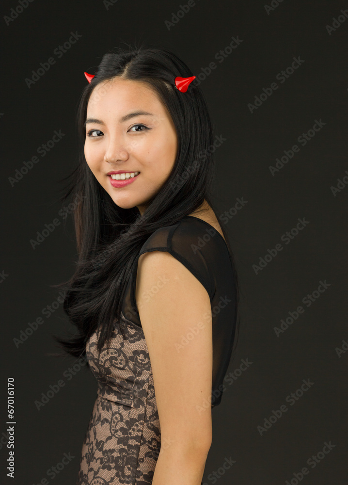 Asian young woman dressed up as an devil smiling Asian young woman dressed up as an devil smiling