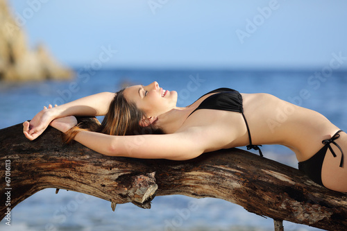 Beautiful woman wearing bikini sunbathing on the beach