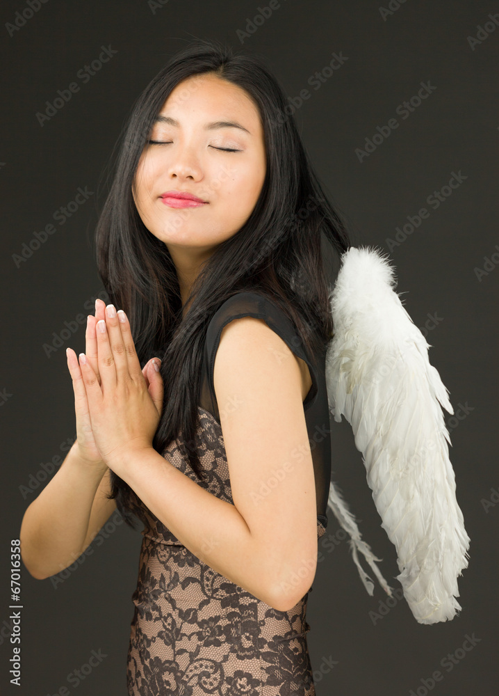 Asian young woman dressed up as an angel in prayer position Asian young woman dressed up as an angel in prayer position