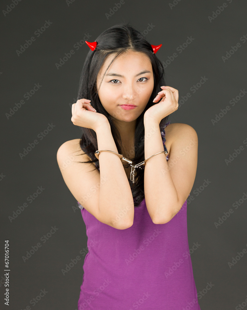 Devil side of a young Asian woman with handcuffs and looking sad Stock Photo Adobe Stock