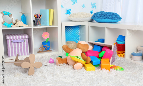 Colorful toys on fluffy carpet in children room © Africa Studio