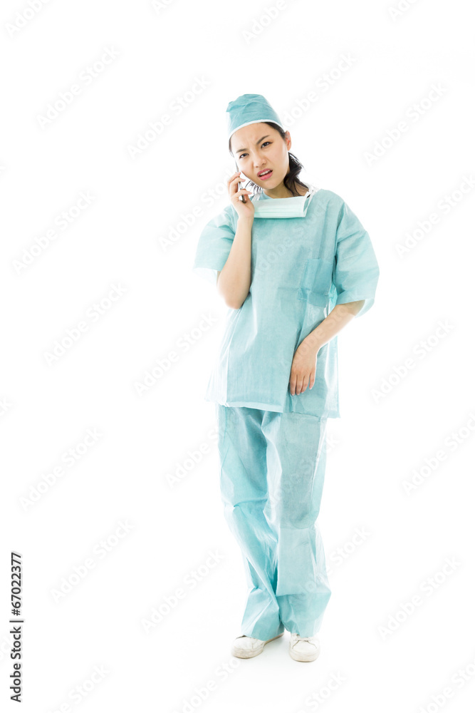Asian female surgeon talking on the mobile phone looking worried Asian female surgeon talking on the mobile phone looking worried