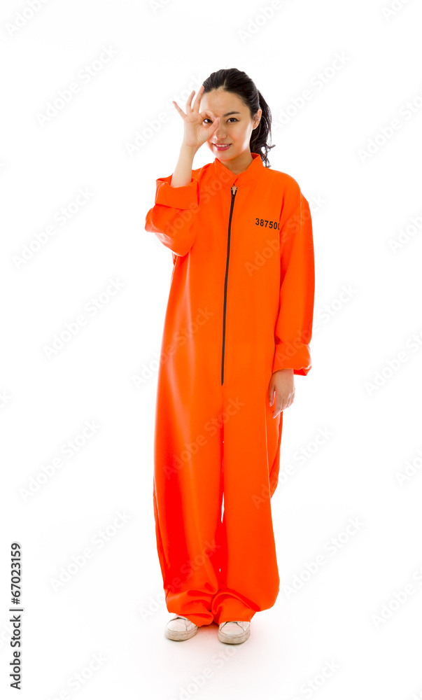 Young Asian woman showing OK sign in prisoners uniform Young Asian woman showing OK sign in prisoners uniform