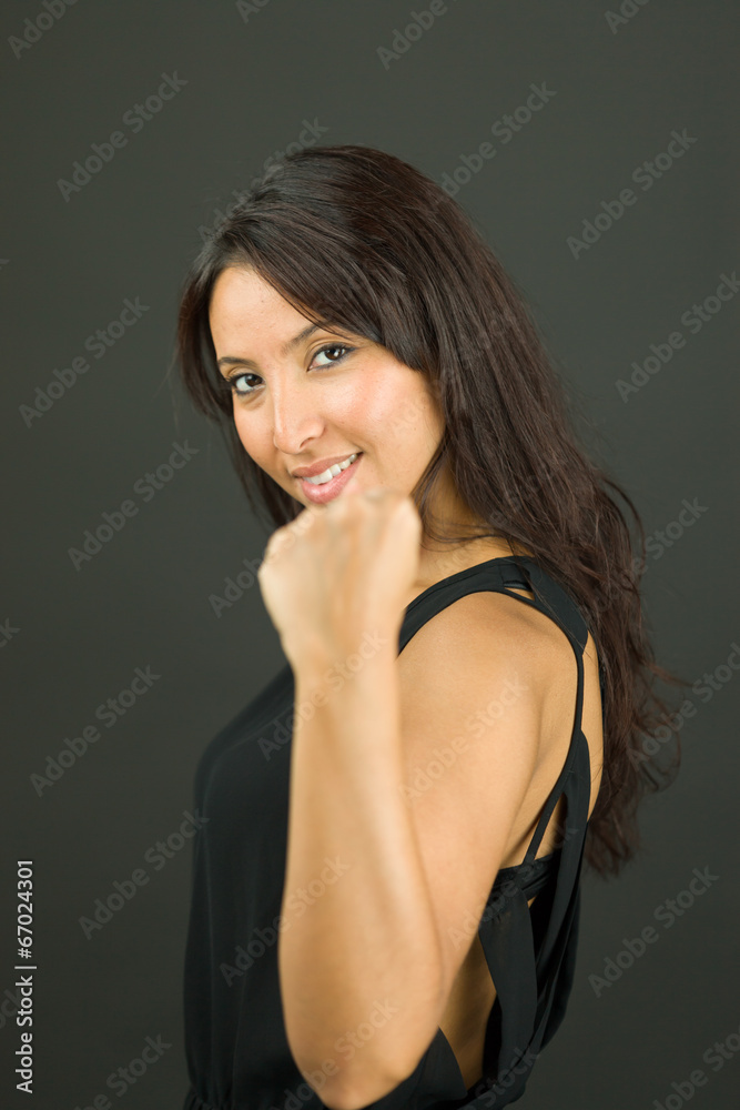Fototapeta premium Excited young woman showing fist and celebrating success