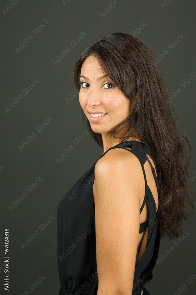 Side profile of a young woman smiling and looking confident Side profile of a young woman smiling and looking confident