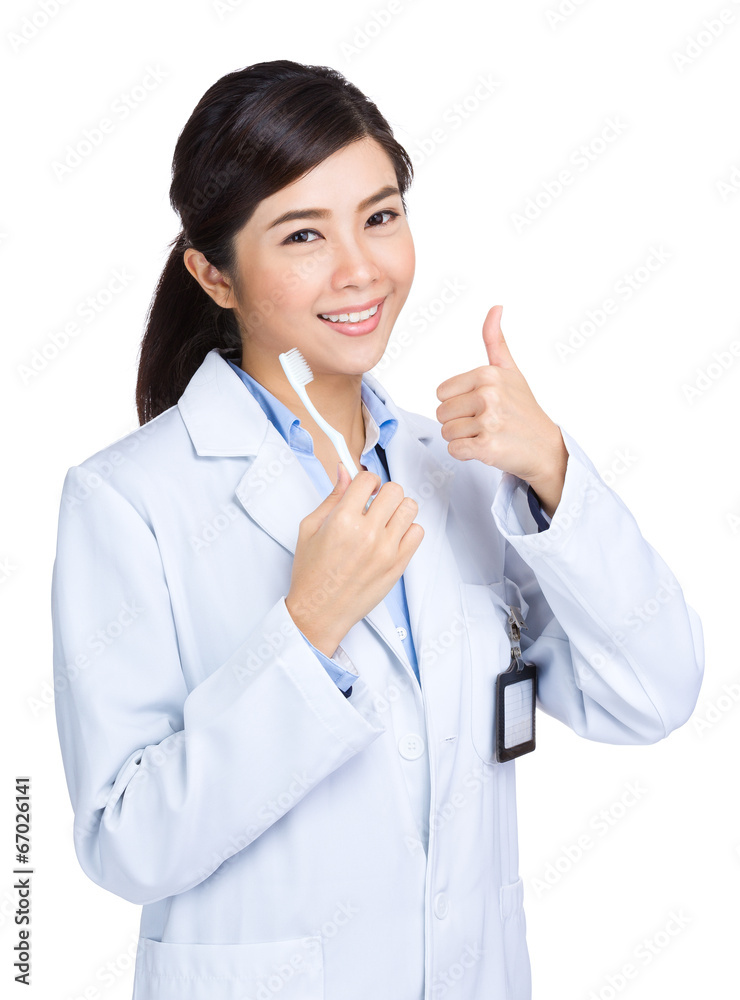 Dental care concept, doctor hold toothbrush with thumb up Dental care concept, doctor hold toothbrush with thumb up