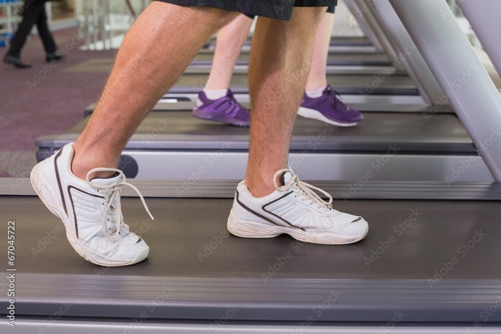 Man and woman walking on treadmills Man and woman walking on treadmills