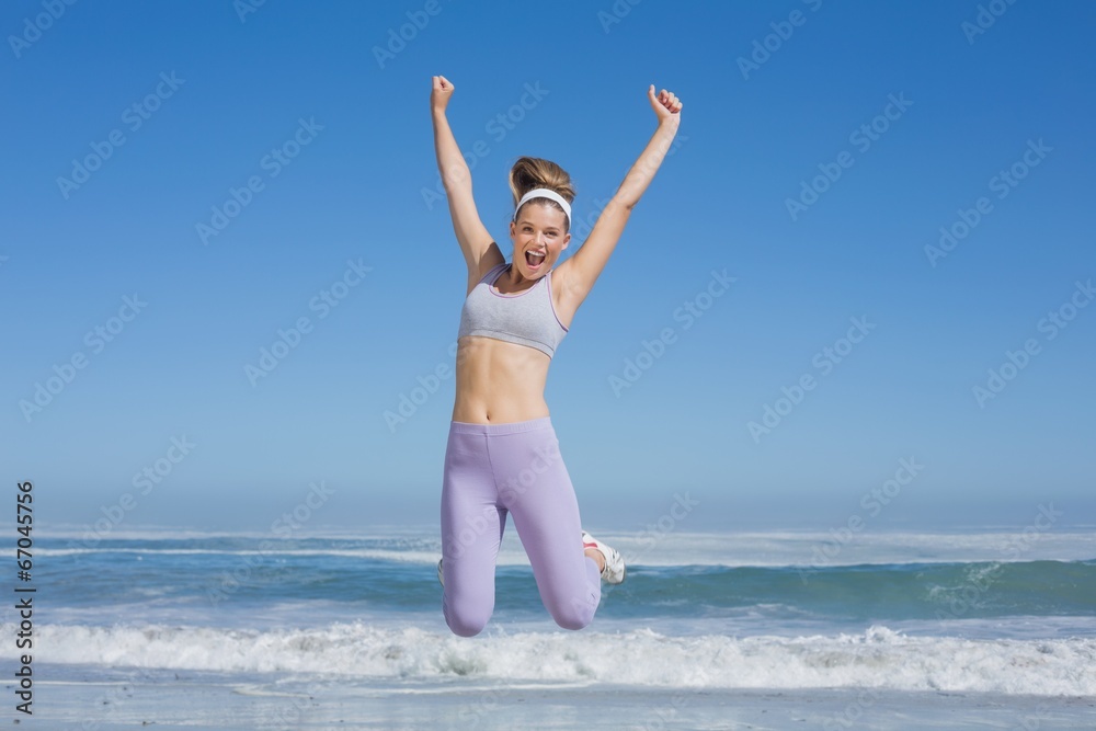 Sporty happy blonde jumping on the beach Sporty happy blonde jumping on the beach