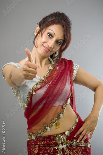 Young Indian woman showing thumb up sign and smiling