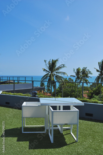Terrace lounge with white rattan armchairs and seaview in a luxu