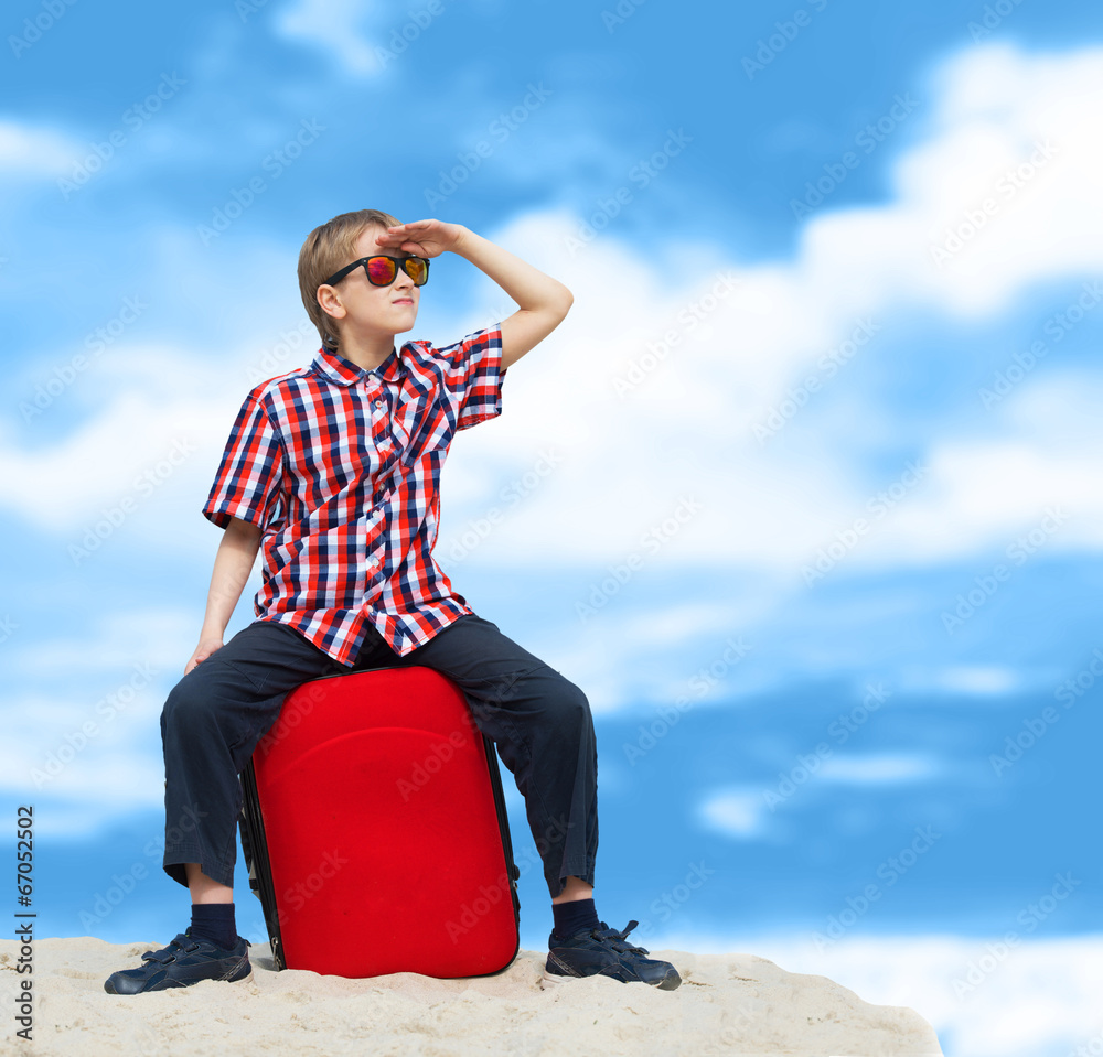 Fototapeta premium Lost boy with his luggage, tropical beach background